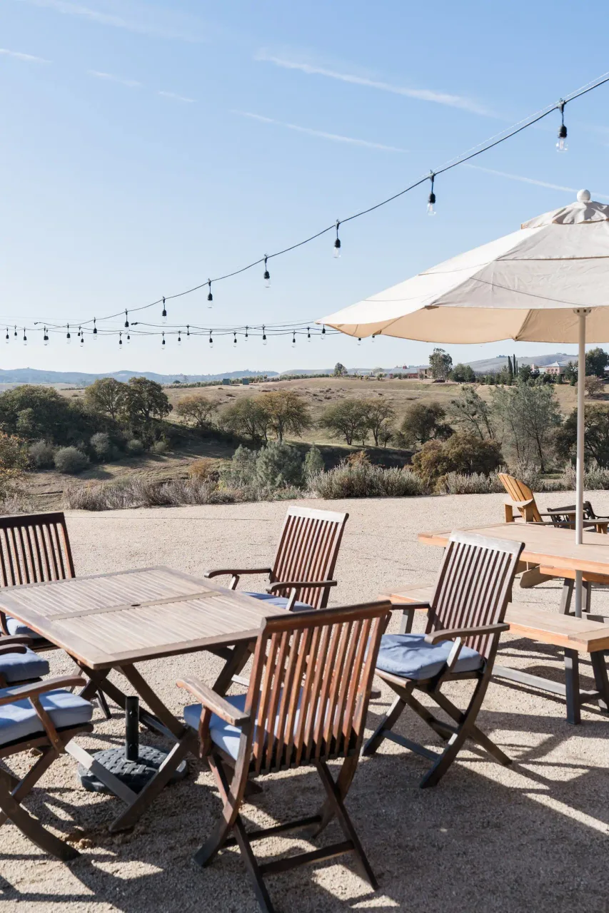Outdoor dining area at Horsetail Ranch with string lights and panoramic hill views